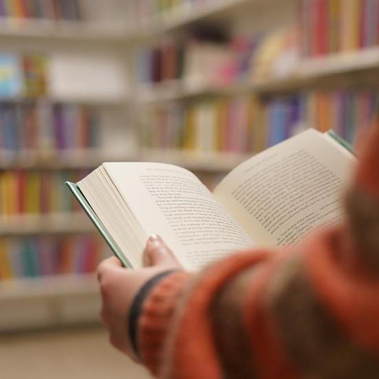 Læsende person i bibliotek