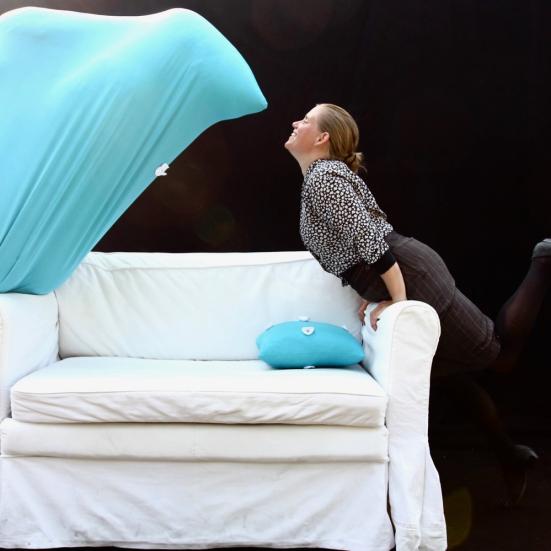 Dame med et blåt spøgelse ved en hvid sofa
