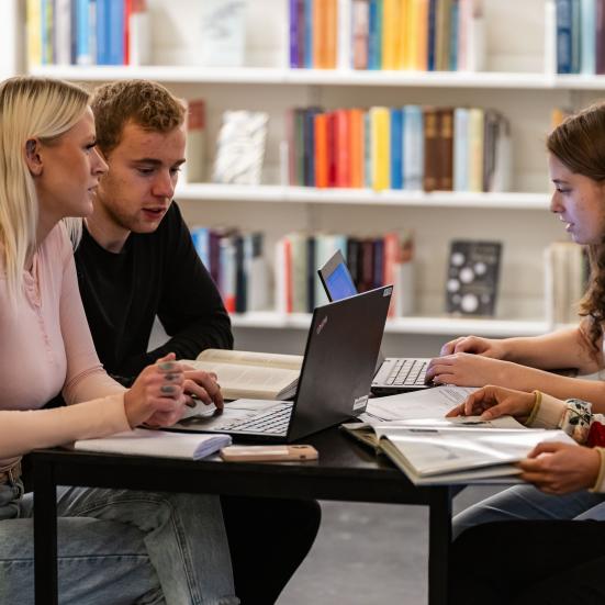 Fire unge studerende omkring et bord