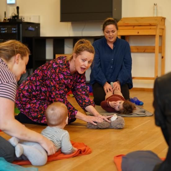 Rundkreds af babyer med syngende forældre