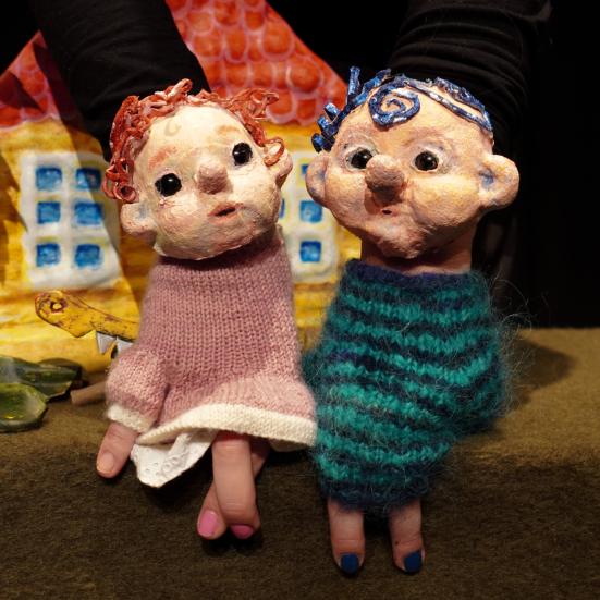 To dukker sidder ved et hus