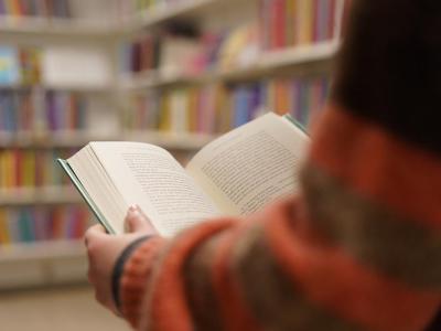 Læsende person i bibliotek