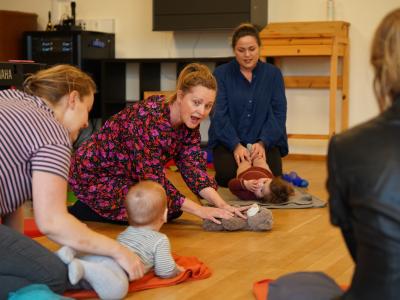 Rundkreds af babyer med syngende forældre