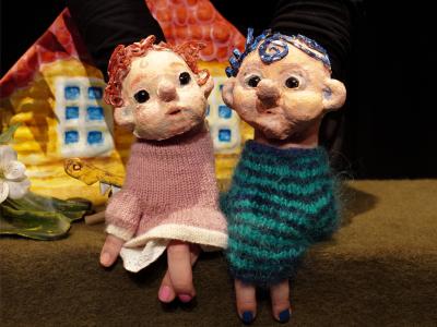 To dukker sidder ved et hus